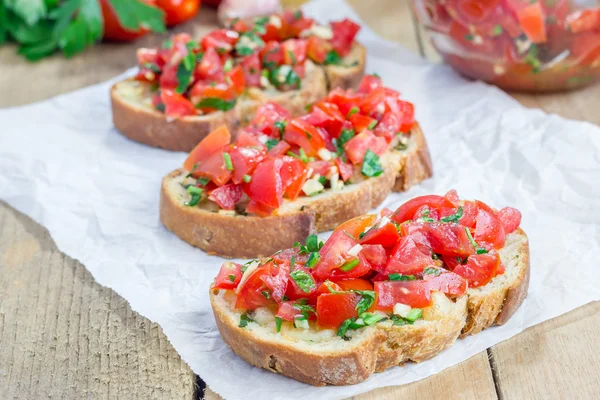 Bruschetta z pomidorami, ziołami i oleju na Pieczywo czosnkowe tosty ser — Zdjęcie stockowe