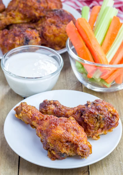 Frango assado servido com aipo e palitos de cenoura, molho de queijo azul e molho picante — Fotografia de Stock