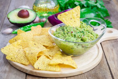 Tıknaz guacamole cips ve malzemelerin üzerine backgroung ile servis ile kase
