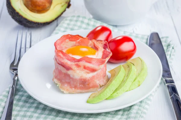 Baked eggs with avocado in bacon cups for breakfast — Stock Photo, Image