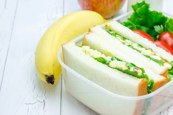 午餐盒与鸡蛋沙拉三明治、 苹果、 香蕉和牛奶 — 图库照片