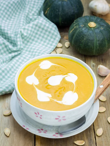 Soupe de citrouille à la crème sure sur une table en bois — Photo