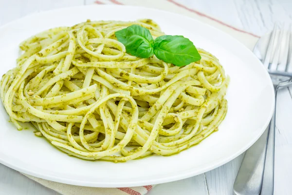 Tagliatelle pasta with pesto sauce on a white plate Royalty Free Stock Images