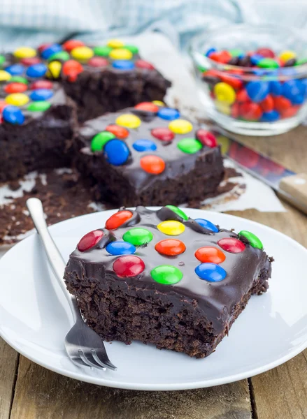 Bolinhos caseiros com ganache de chocolate e doces coloridos — Fotografia de Stock