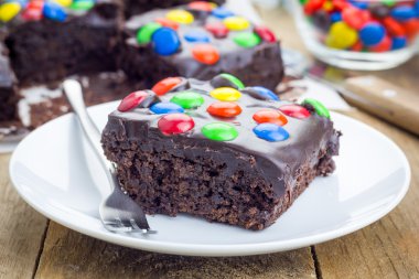 Homemade brownies with chocolate ganache and colorful candies clipart