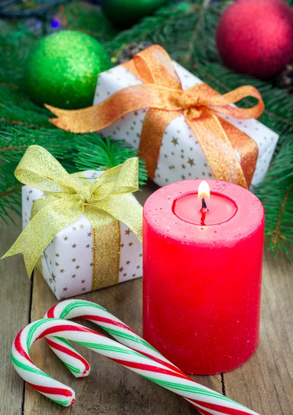 Composición navideña con caja de regalo, bastones de caramelo y vela, primer plano — Foto de Stock