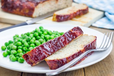 Ev yapımı köfte beyaz bir plaka üzerinde yeşil bezelye ile süslenmiş