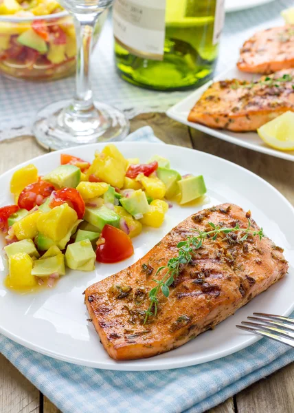 Salmão grelhado com especiarias com salsa de manga-abacate em um prato branco — Fotografia de Stock