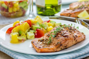 Baharat beyaz tabakta mango-avokado salsa ile ızgara somon