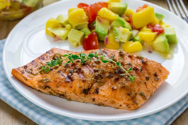 Salmão grelhado com especiarias com salsa de manga-abacate em um prato branco — Fotografia de Stock