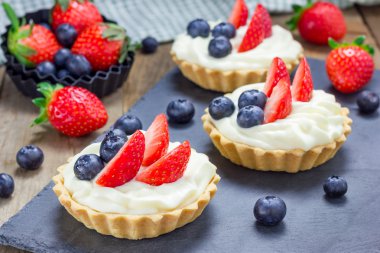 Ev yapımı kurabiye tartlets muhallebi krem, çilek ve yaban mersini