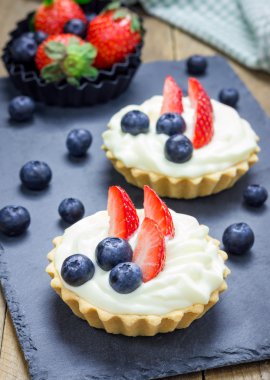 Ev yapımı kurabiye tartlets muhallebi krem, çilek ve yaban mersini