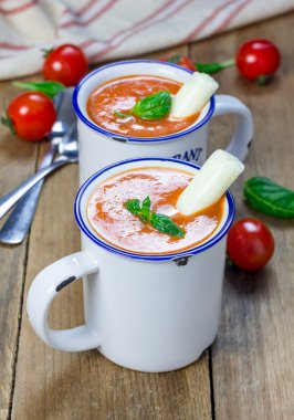 Ev yapımı domates fesleğen çorbası kupa, mozzarella peynir sopa ve kruton ile servis edilir