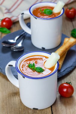 Ev yapımı domates fesleğen çorbası kupa, mozzarella peynir sopa ve kruton ile servis edilir