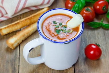 Ev yapımı domates fesleğen çorbası kupa, mozzarella peynir sopa ve kruton ile servis edilir