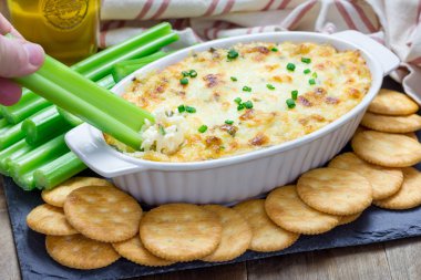 Pişmiş Yengeç daldırma, kereviz sopa ve kraker ile servis edilir