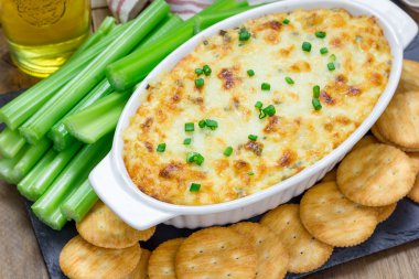 Pişmiş Yengeç daldırma, kereviz sopa ve kraker ile servis edilir