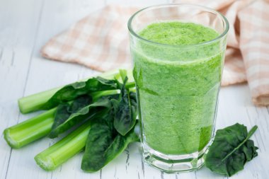 Kereviz, salatalık, ıspanak, elma ve limon bir beyaz tahta masada yeşil smoothie