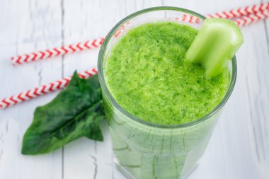 Kereviz, salatalık, ıspanak, elma ve limon bir beyaz tahta masada yeşil smoothie