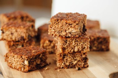 Dört dilim elmalı ve cevizli ekmeğin yakın çekimi. Tahtaya yerleştirilmiş. Yan görünümü kapat