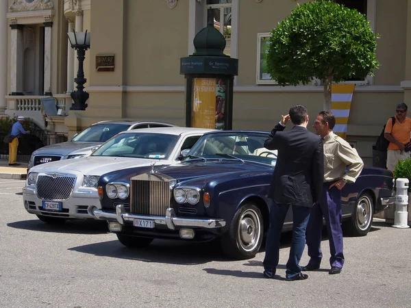 Monaco, Monte Carlo - 15 Mayıs 2018: Fransız Rivierası 'nı ziyaret eden bir Alman fotoğrafçı, bir günlük Monako gezisi, önünde pahalı arabalar olan ünlü kumarhanenin fotoğraflarını çekiyor..