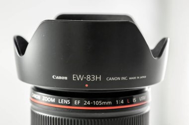 Frankfurt, Germany -March 21st 2021: A german photographer taking detailed pictures of his Canon EF 24-105 L F4.0 lens in order to sell it on eBay after changing his camera system from EF to RF mount. clipart