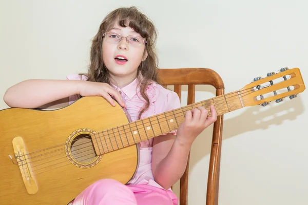 Jovem menina tocando guitarra acústica — Fotografia de Stock