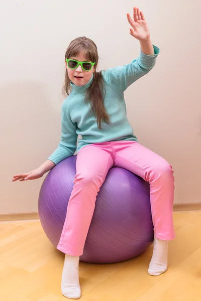 Jeune petite fille assise sur une grosse boule — Photo