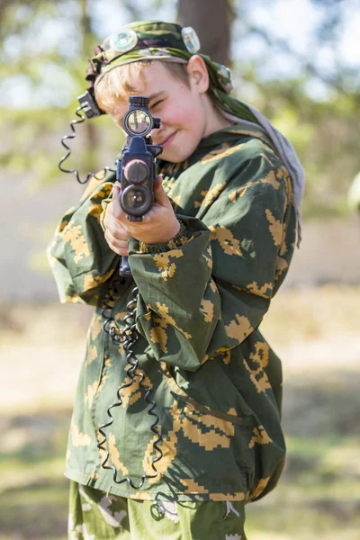 Lazer oyunu oynayan silahlı bir çocuk.
