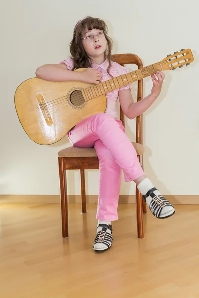 Jovem menina tocando guitarra acústica — Fotografia de Stock