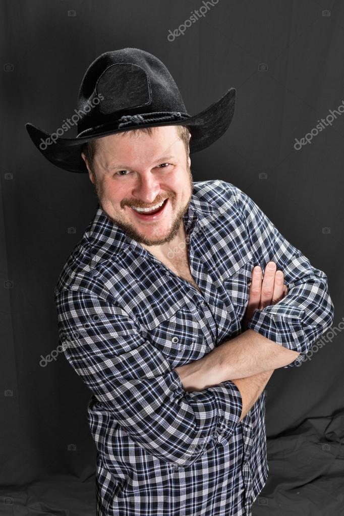 Cowboy man at plaid shirt with black hat studio portrait