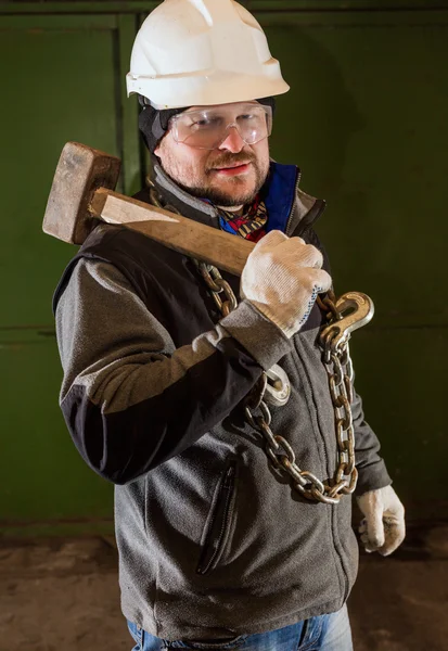 Tough worker with iron chain and sledgehammer