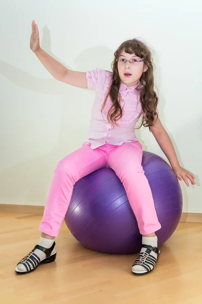 Jeune petite fille assise sur une grosse boule — Photo