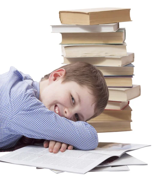 Young boy in classic  dress lying with heap of books on white ba — Stok fotoğraf