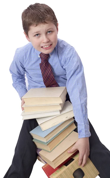 Young boy in classic  dress sitting with heap of books Stock Image
