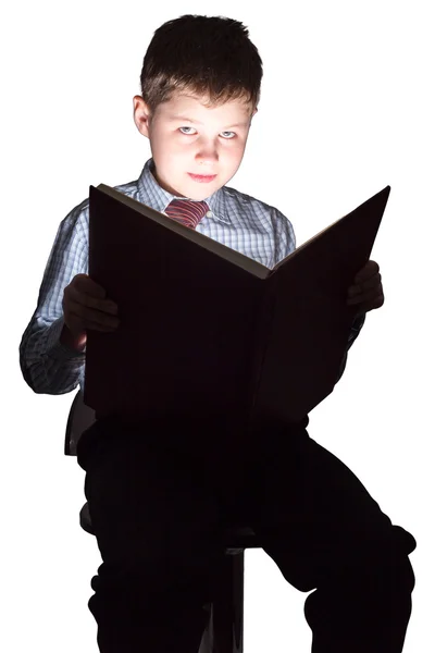 Joven colegial leyendo libro en la oscuridad —  Fotos de Stock