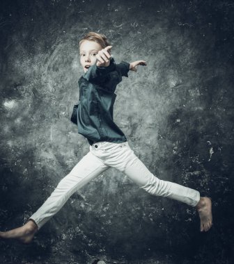 Beyaz kot ve mavi gömlek giymiş genç bir artistik patenci.