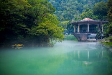 Su üzerinde eski pavyonu olan güzel bir manzara.