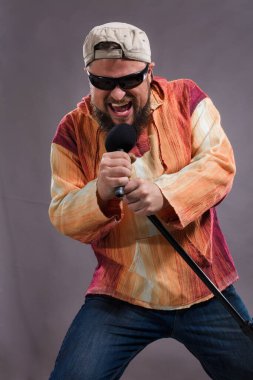 Micriphone stüdyo portresiyle sakallı duygusal rock şarkıcısı.