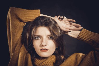 Süveter giymiş güzel bir kadının stüdyo portresi.