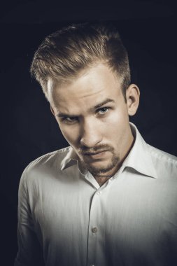 Beyaz gömlekli genç adam stüdyo resmi.