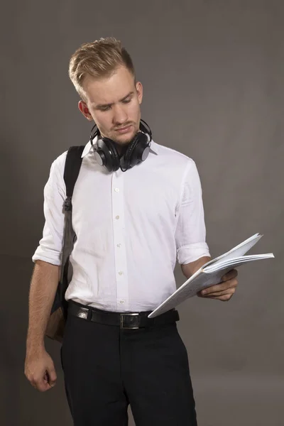 Jeune étudiante habillée en chemise blanche regardant les papiers — Photo