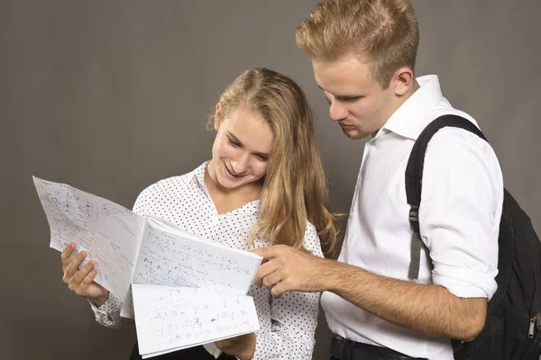 Két diák fiatal férfi és nő nézi az újságokat — Stock Fotó