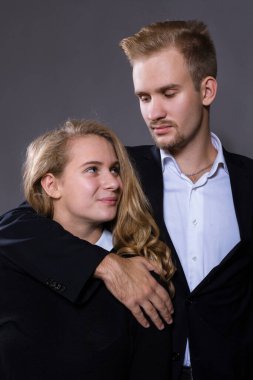 Gri arkaplanda genç ve güzel bir çift stüdyo resmi.