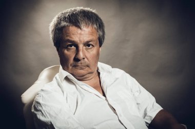 Gri arkaplanda orta yaşlı adam portresi.