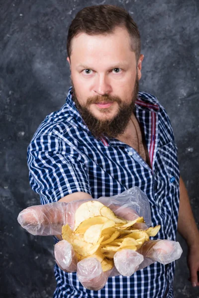 Uomo barbuto solido a vestiti casual con mucchio di patatine fritte — Foto Stock