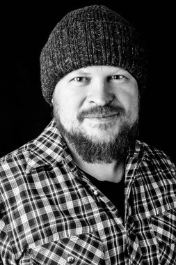 Katı sakallı, yün şapkalı bir adam.