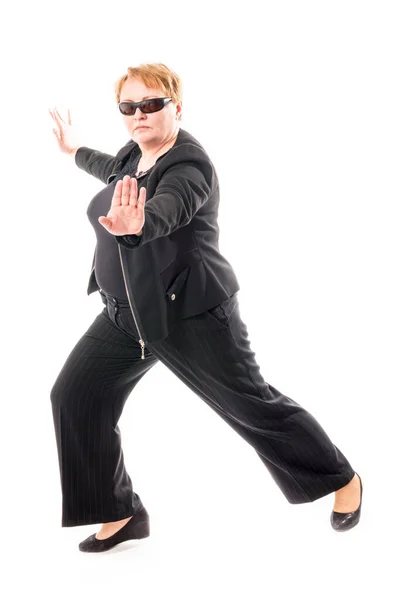 Женщина средних лет в черной куртке и брюках танцует эмоциональный танец — стоковое фото