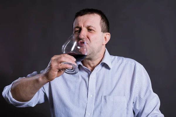 Middelbare leeftijd vrolijke man gekleed in een shirt met glas wijn — Stockfoto