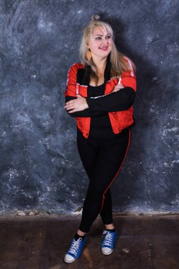 Spor tarzı giyinmiş çekici, tombul bir kadın.